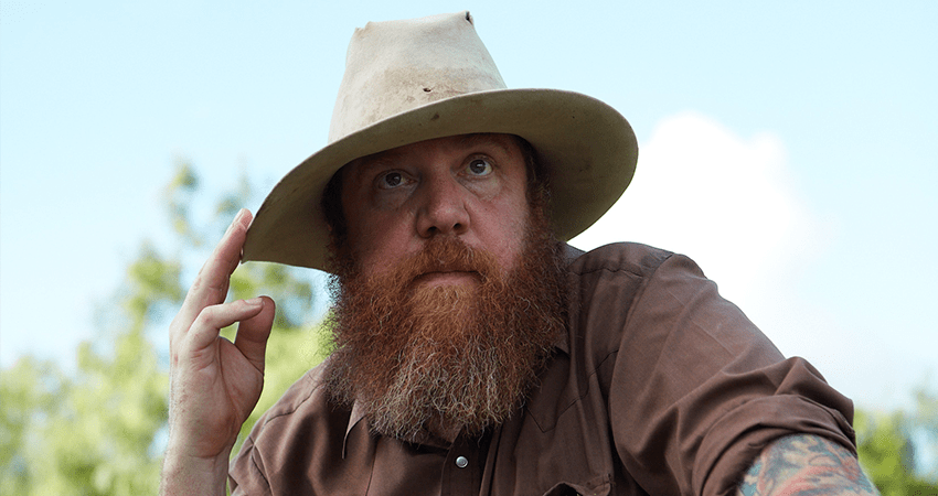 hunter in brown button up shirt and tan hat