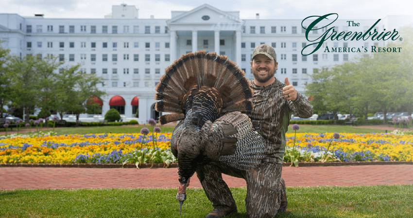 man posing with turkey in front of the Greenbrier Resort